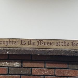 Wooden sign/ Laughter is the music of the heart